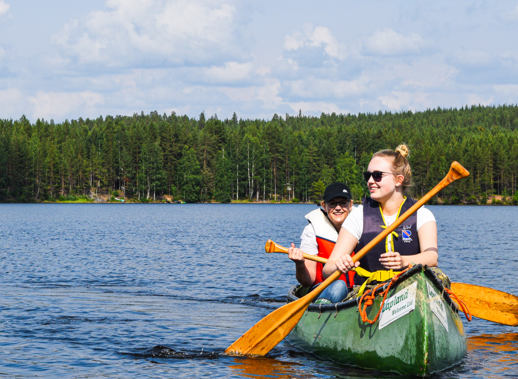 two people paddling in kanu on lake