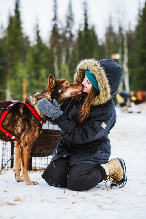 woman cuddling a Husky